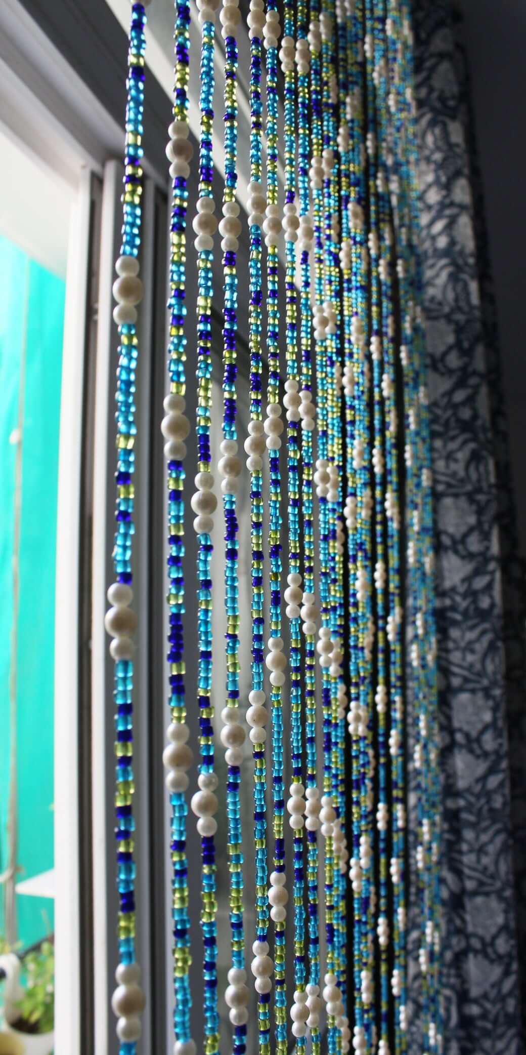 Handmade colorful glass bead strands with jingle bells—perfect for doorways or wall décor. Eco-friendly and crafted by women's artisans in India.